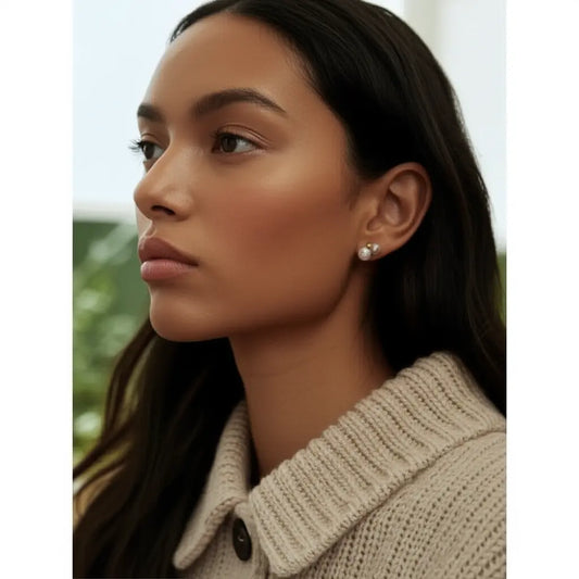 Close-up of a woman wearing pearl earrings with a blurred background