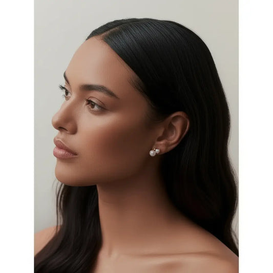 Woman wearing pearl earrings with a neutral background