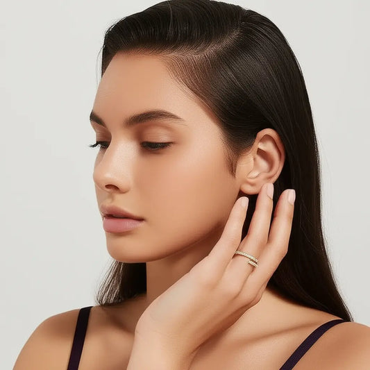 Woman adjusting an earring with a neutral background