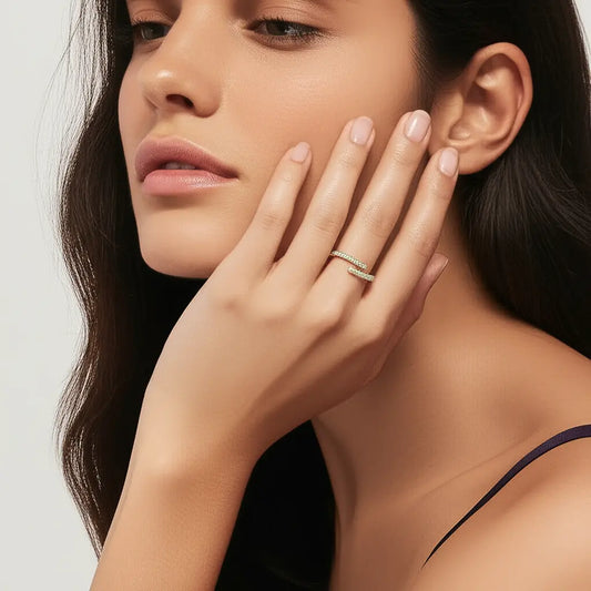 Close-up of a woman wearing a gold ring on her finger, with a neutral background