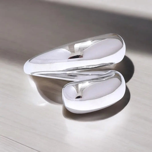White and silver earring on a light wooden surface
