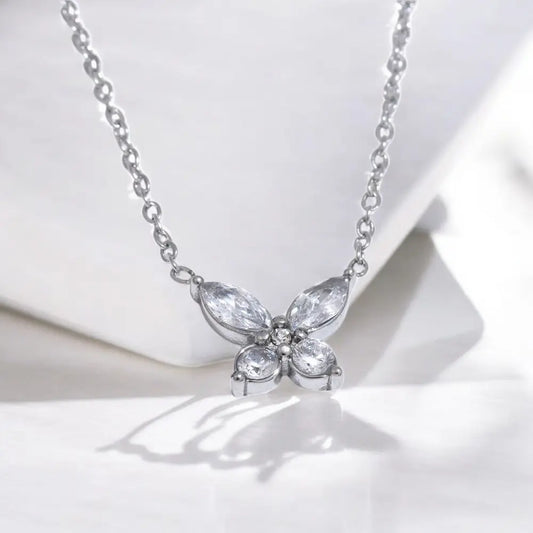 Butterfly-shaped necklace with clear stones on a white background