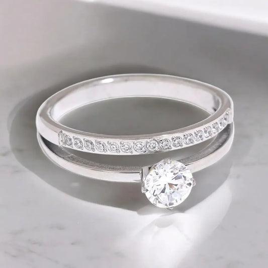 Silver ring with a diamond on a marble surface