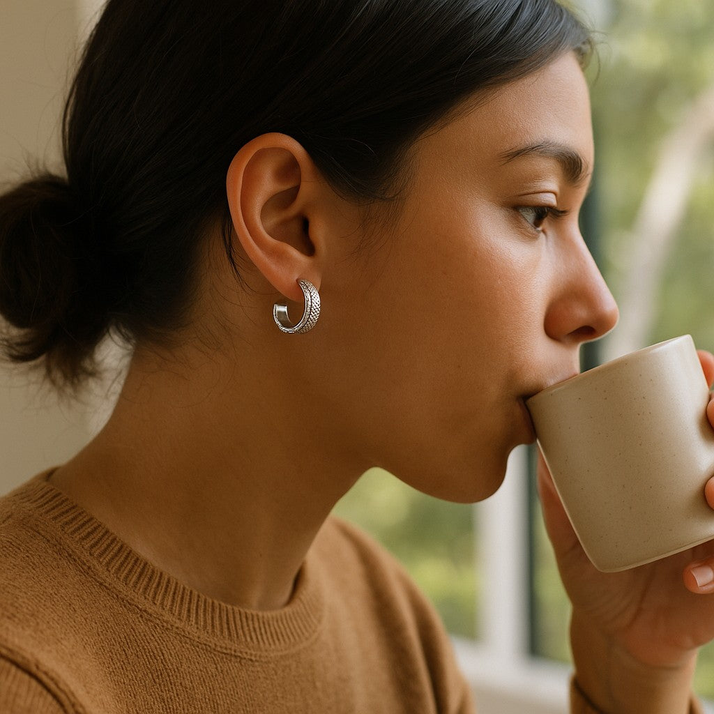 Woman drinking from a beige mug indoors