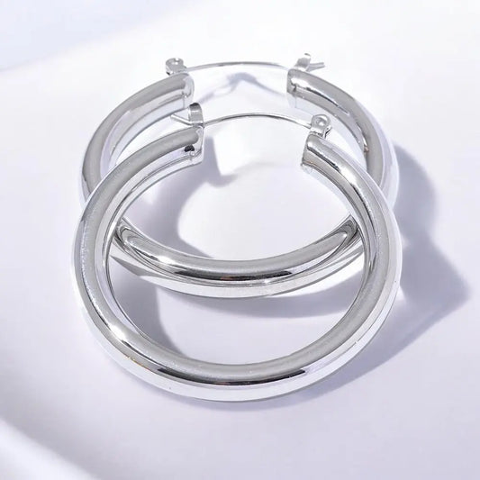 Silver hoop earrings on a light gray background