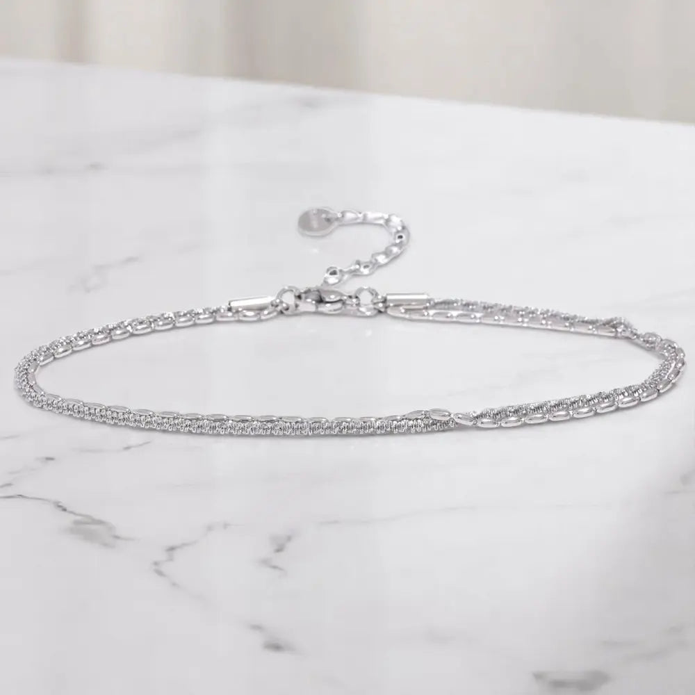 Silver chain bracelet on a marble surface
