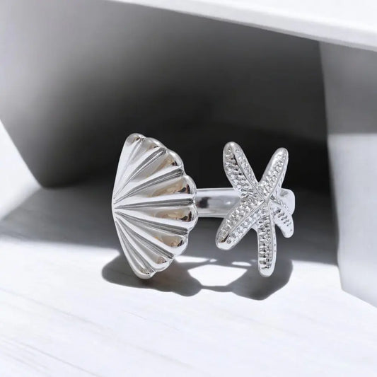 Silver shell and starfish earrings on a light background