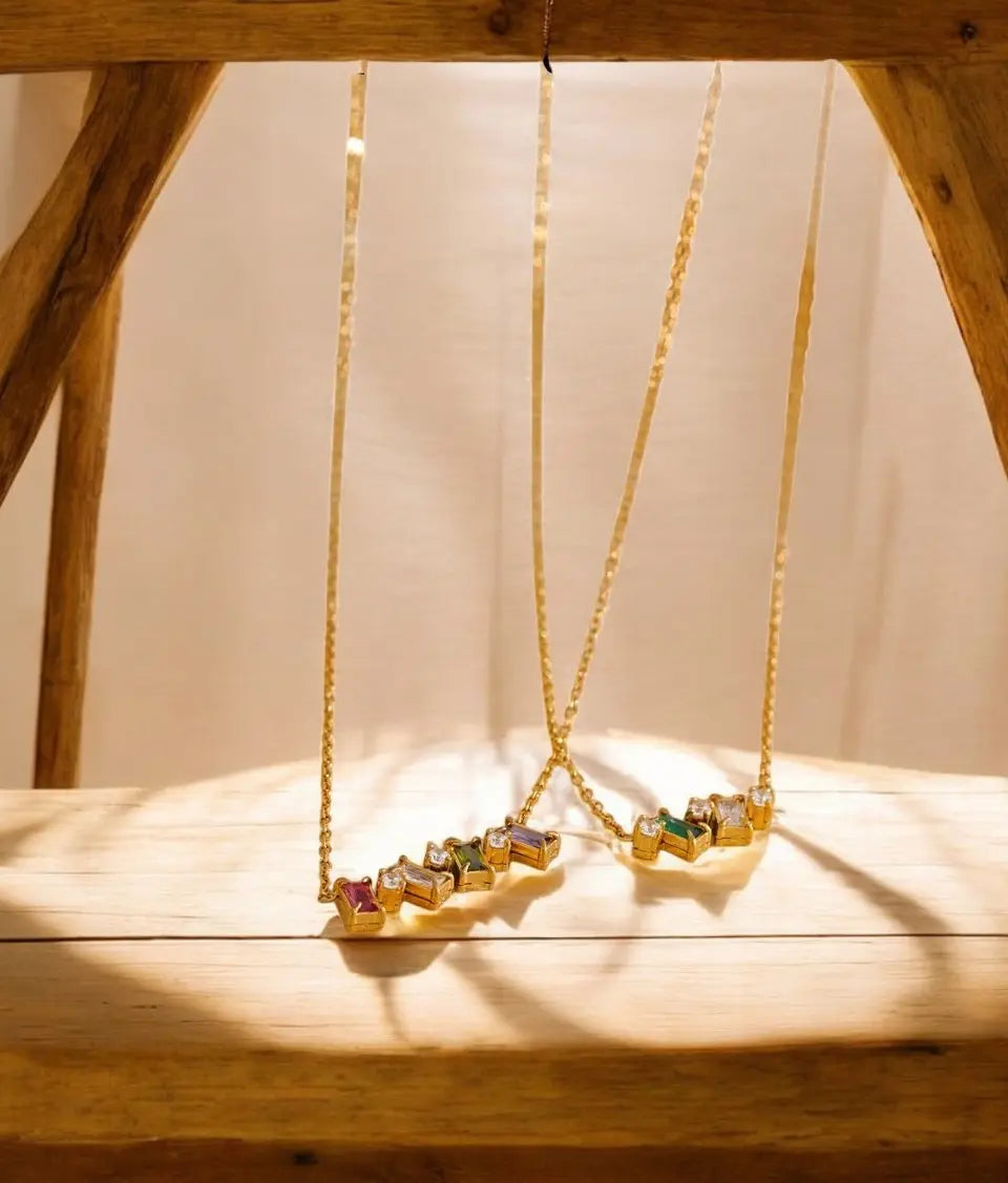 Gold necklace with colorful gemstones on a wooden surface