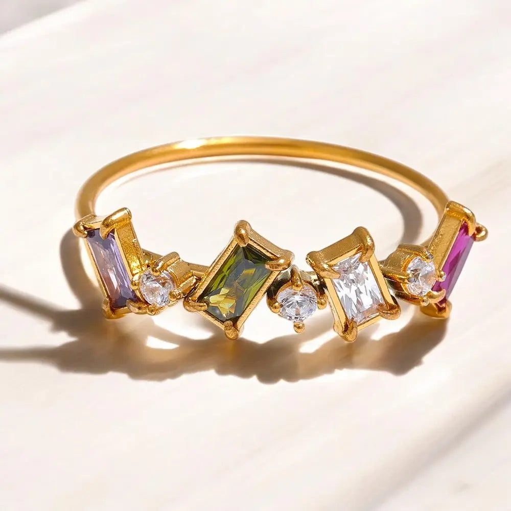 Gold bracelet with colorful gemstones on a light background
