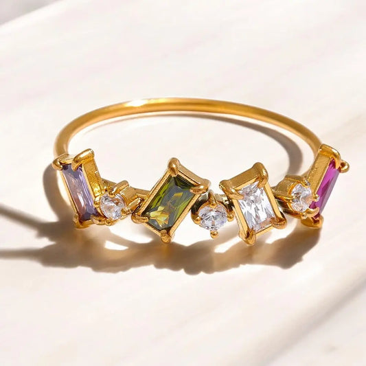 Gold bracelet with colorful gemstones on a light background