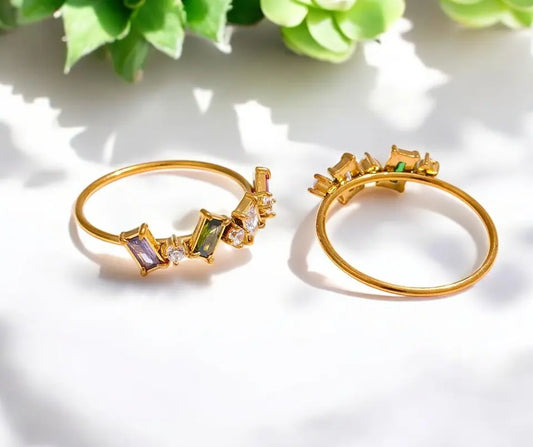 Gold hoop earrings with gemstones on a light background