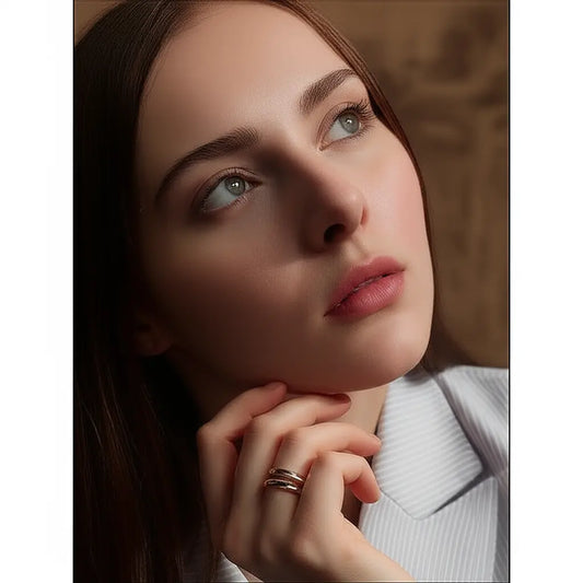 Close-up of a woman with a neutral expression, wearing a light-colored top.
