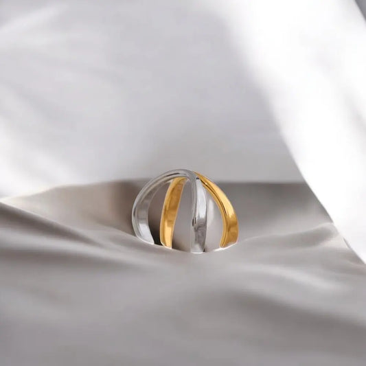 Two-toned ring on a white fabric background