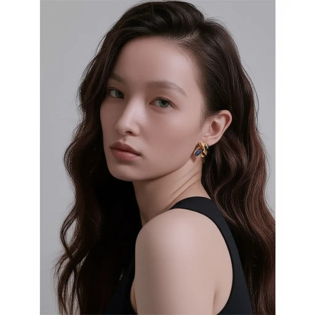 Woman with long dark hair wearing a black sleeveless top against a neutral background
