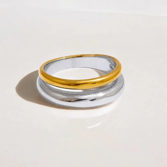 Stack of gold and silver rings on a light beige background