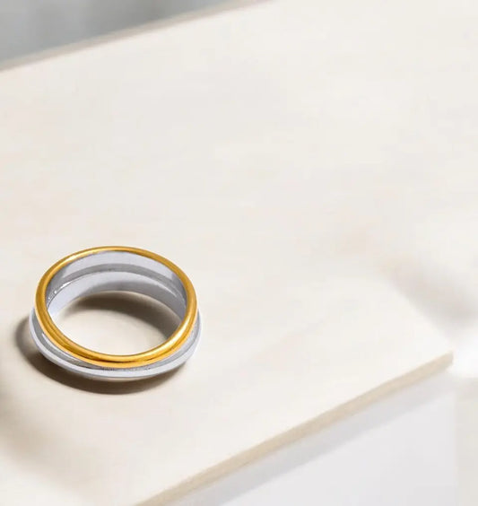 Gold and white ring on a light surface